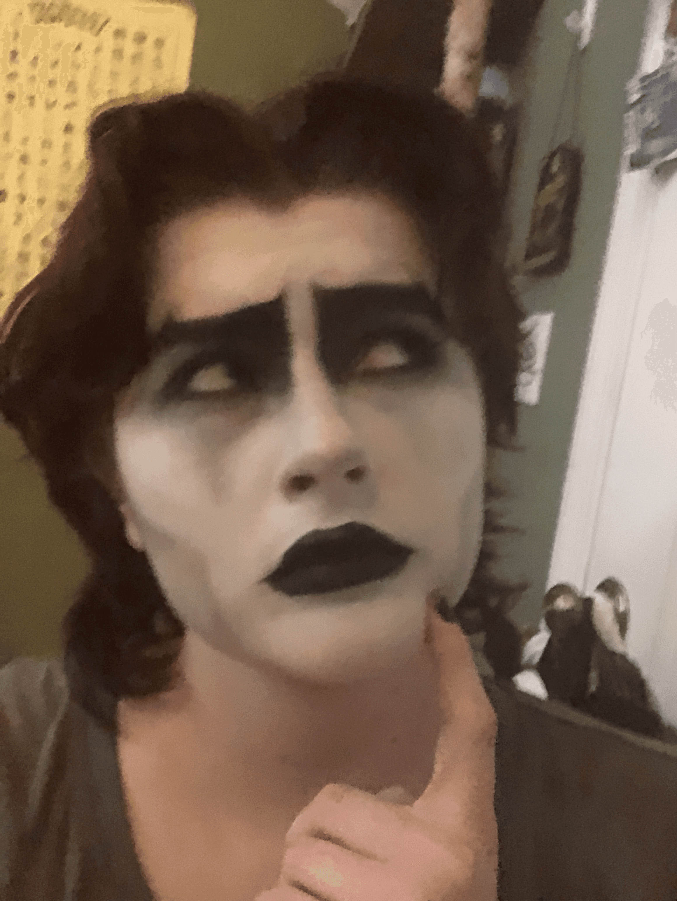 a drag king in a suit with chin length reddish hair and thick black eyebrows and mustache gazes handsomely
